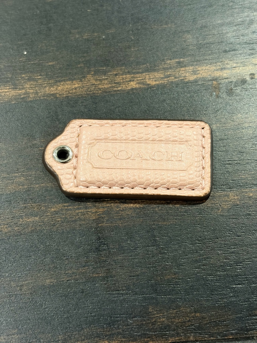 Light pink snakeskin embossed Coach hangtag